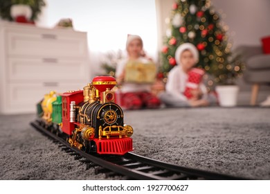 Children playing with colorful toy in room decorated for Christmas, focus on train