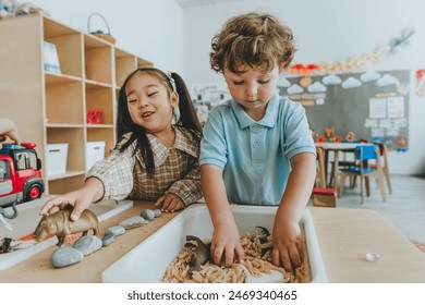 Children playing and developing tactility with toy animal figures in bulk cereals and pasta in kindergarten