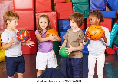 Children playing with different balls in gym of preschool