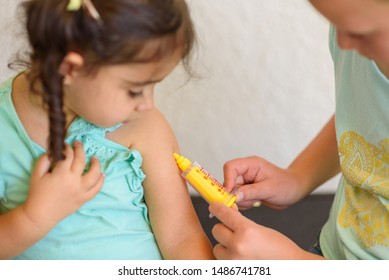 Children Playing Doctor. Doctor Injecting Vaccination Flu Shot In Arm Little Child Girl, Healthy And Medical Concept.