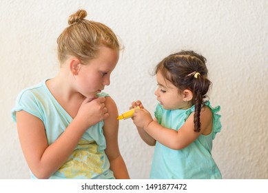 Children Playing Doctor. Doctor Injecting Vaccination Flu Shot In Arm Little Child Girl, Healthy And Medical Concept.