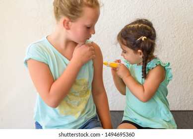 Children Playing Doctor. Doctor Injecting Vaccination Flu Shot In Arm Little Child Girl, Healthy And Medical Concept. Selective Focus On Toddler Girl.