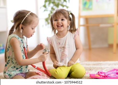Children playing doctor in kindergarten, playschool, daycare center or home