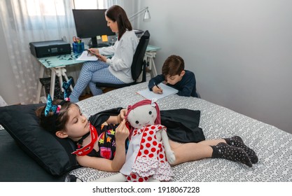 Children playing and doing homework while their mother works at home. Conciliation family work concept