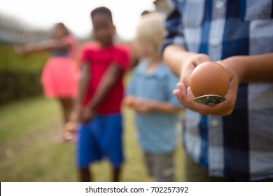 Children playing egg and spoon race while standing in yard during party - Powered by Shutterstock