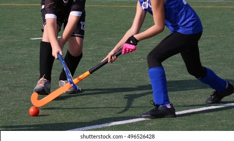 Children playing field hockey on dry turf field - Powered by Shutterstock