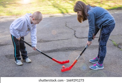 children are playing hockey on the street