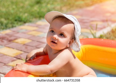 Children Playing In Inflatable Baby Pool. Kids Swim And Splash In Colorful Garden Play Center. Happy Boy And Girl Playing With Water Toys On Hot Summer Day. Family Having Fun Outdoors In The Backyard