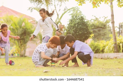 Children Playing Lagori, Dikori Or Lagoori Outdoor Traditional Game, Where Two Teams Try To Hit A Pile Of Stones With Ball - Concept Of Kids Enjoying Outdoor Games In Technology Driven World