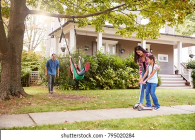 Children Playing On Garden Swing And Scooter Outside House - Shutterstock ID 795020284