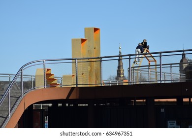 Children Playing On A Jungle Gym On An Elevated Platform At The Harbor In Copenhagen, Denmark With A Building Tower In The Background.Taken In March 2017.