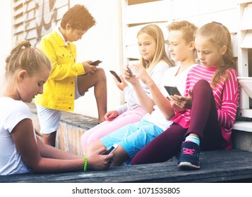 Children are playing on smartphone in the playground. - Shutterstock ID 1071535805