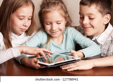 Children playing on tablet. Kids looking at computer