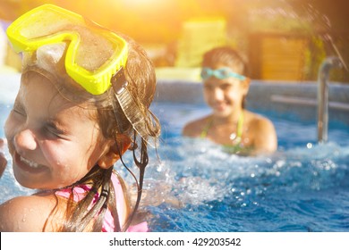 Дети играют в бассейне. Две маленькие девочки весело провести время в бассейн. Летние каникулы и концепция отдыха