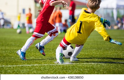 Children Playing Soccer Football Match. Youth Soccer Forward and Goalkeeper Duel. Football soccer game. Players footballers running and playing football match. Forward footballer against goalkeeper.