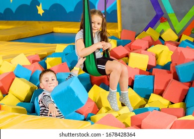 Children Playing With Soft Cubes In The Dry Pool In Play Center. Playground With Foam Blocks In Trampoline Club