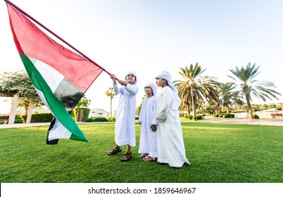 Children Playing Together In Dubai In The Park. Group Of Kids Wearing Traditional Kandura White Dress From Arab Emirates