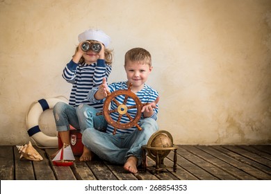 Children Playing With Vintage Nautical Things. Kids Having Fun At Home. Travel And Adventure Concept. Retro Toned Image