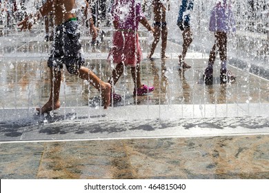 children  playing with water in park fountain. Hot summer. Happy children have fun playing in water fountains