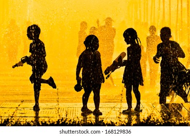 children playing in water silhouette
