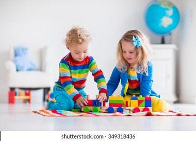 Children Playing With Wooden Train. Toddler Kid And Baby Play With Blocks, Trains And Cars. Educational Toys For Preschool And Kindergarten Child. Boy And Girl Build Toy Railroad At Home Or Daycare.