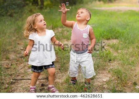 Similar – children playing in the sand, having a conversation over sand toys