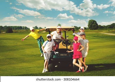 Children posing near golf car at golf course at summer day