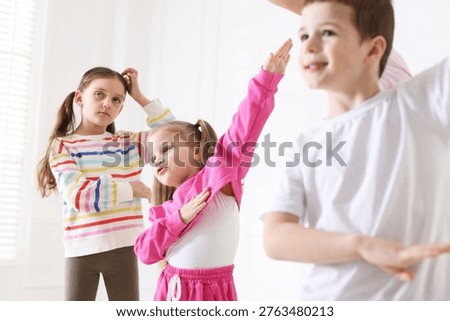 Children practicing dance moves during class in studio, selective focus