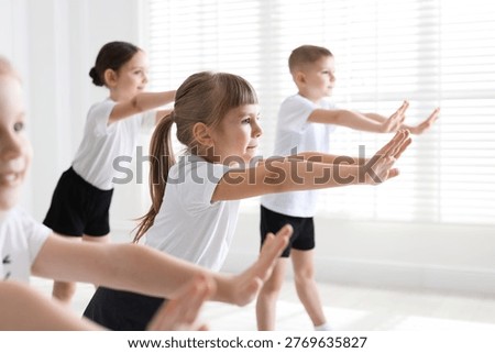 Children practicing dance moves during class in studio, selective focus