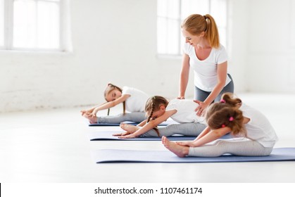 Children Practicing Are Engaged In Gymnastics And Yoga With  Teacher
