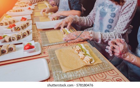 Children prepare sushi and rolls. Master-class restaurant.