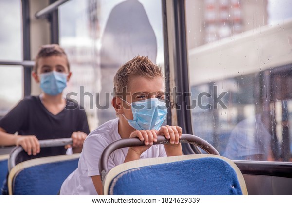 Children in public transport with protective masks\
on their faces