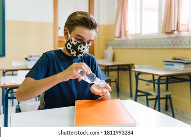 Children Putting Sanitizer Gel On Their Hands In The School Classroom. Covid.