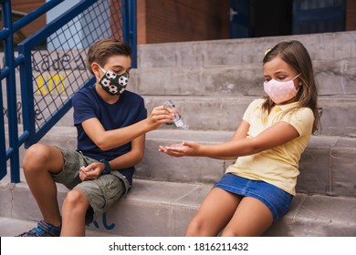 Children Putting Sanitizer Gel On Their Hands In The School Classroom. Covid.