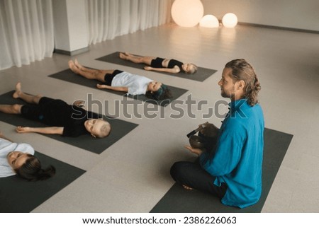 Children relax lying down to the sounds of a Tibetan bowl in the fitness room. Children's yoga.