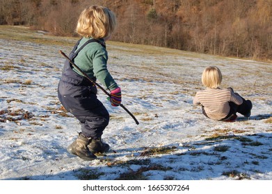 Children Rolling Downhill In Winter