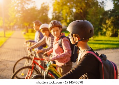 Children with rucksacks riding on bikes in the park near school. Students with backpacks outdoors - Powered by Shutterstock