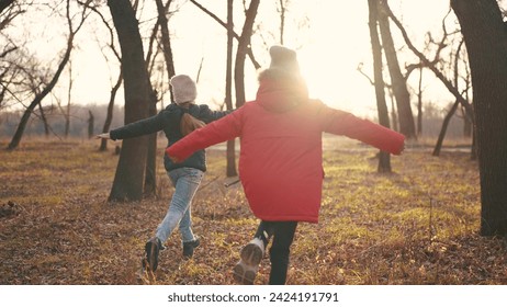 children run in the forest in autumn park. happy family kid dream concept. group of children in jackets in the fall run in a park in the forest. nature freedom childhood concept - Powered by Shutterstock