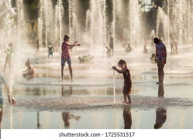 Children Run And Frolic In The Spray Of Fountains On The Place Massena In Nice.