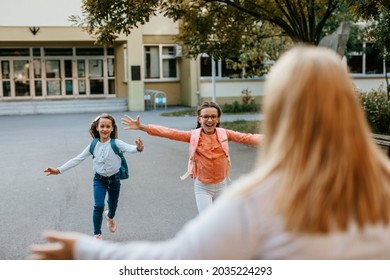 The Children Run Into Their Mother's Arms After Finishing Their First Day Of School.