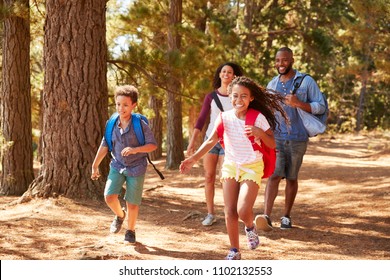 Children Running Ahead Of Parents On Family Hiking Adventure