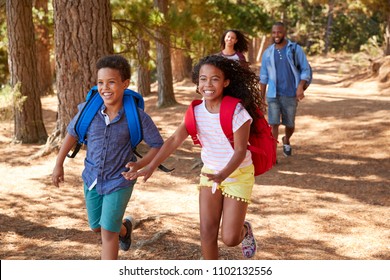 Children Running Ahead Of Parents On Family Hiking Adventure