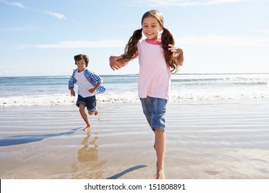 Children Running Away From Breaking Waves On Beach