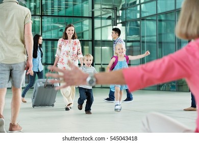 Children running excitedly towards grandmother - Powered by Shutterstock