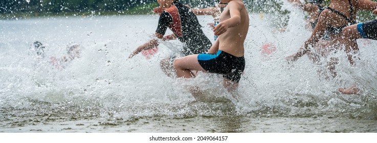 Children Running Into A Lake During A Kids Triathlon Competition