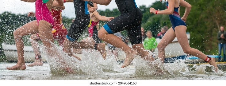 Children Running Into A Lake During A Kids Triathlon Competition