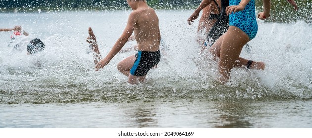 Children Running Into A Lake During A Kids Triathlon Competition