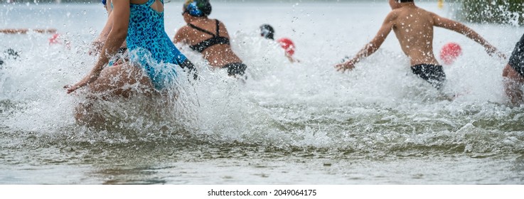 Children Running Into A Lake During A Kids Triathlon Competition