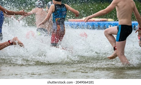 Children Running Into A Lake During A Kids Triathlon Competition