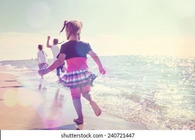 Children running on the beach in the waves - Powered by Shutterstock